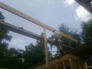 Carpenter setting a ridge beam over a new addition frame — Ice Dam Removal by Roofing Brothers in Aransas Pass