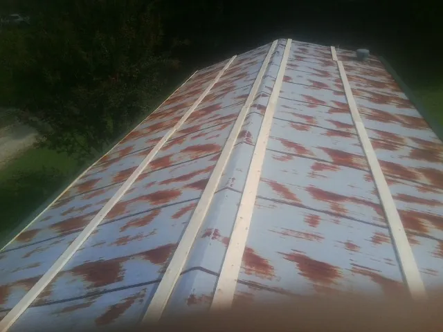Rusted metal roof panels with new wood purlins before replacement — Storm Damage Roof Repair in Aransas Pass by Roofing Brothers