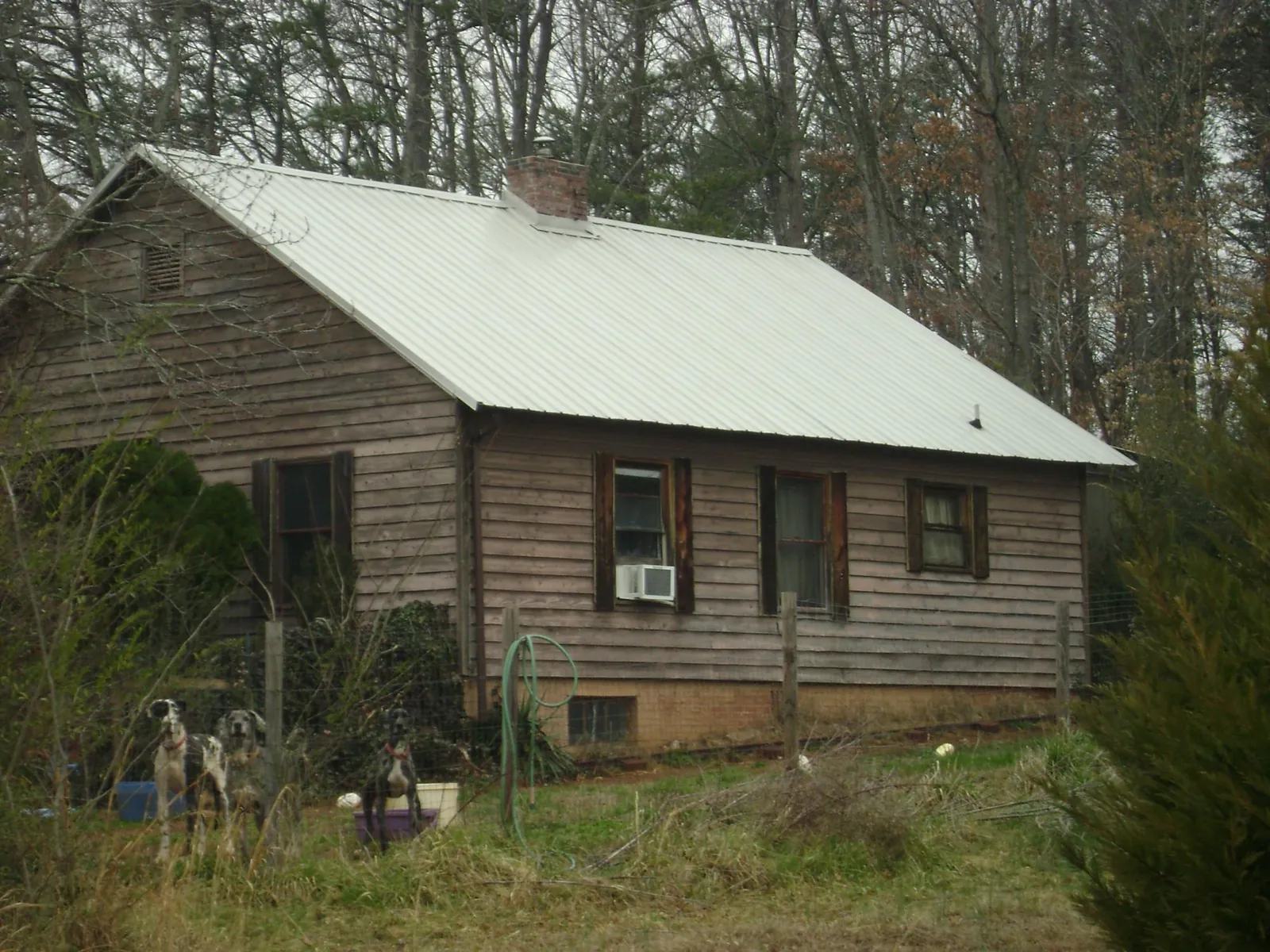 White metal roof on an old wood sided farmhouse, from a Metal Roof Installation job in Aransas Pass